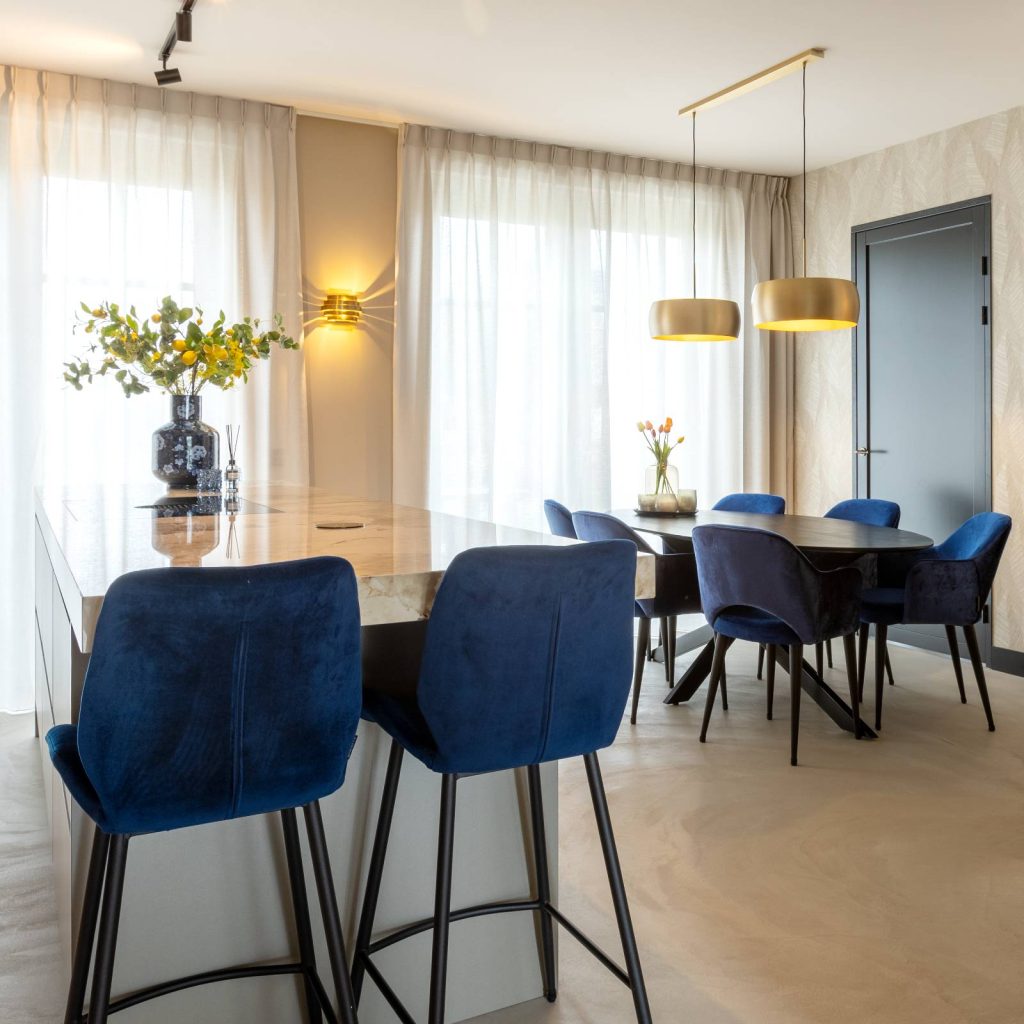 kookeiland met blauwe barkrukken en eiken keukentafel met blauwe stoelen