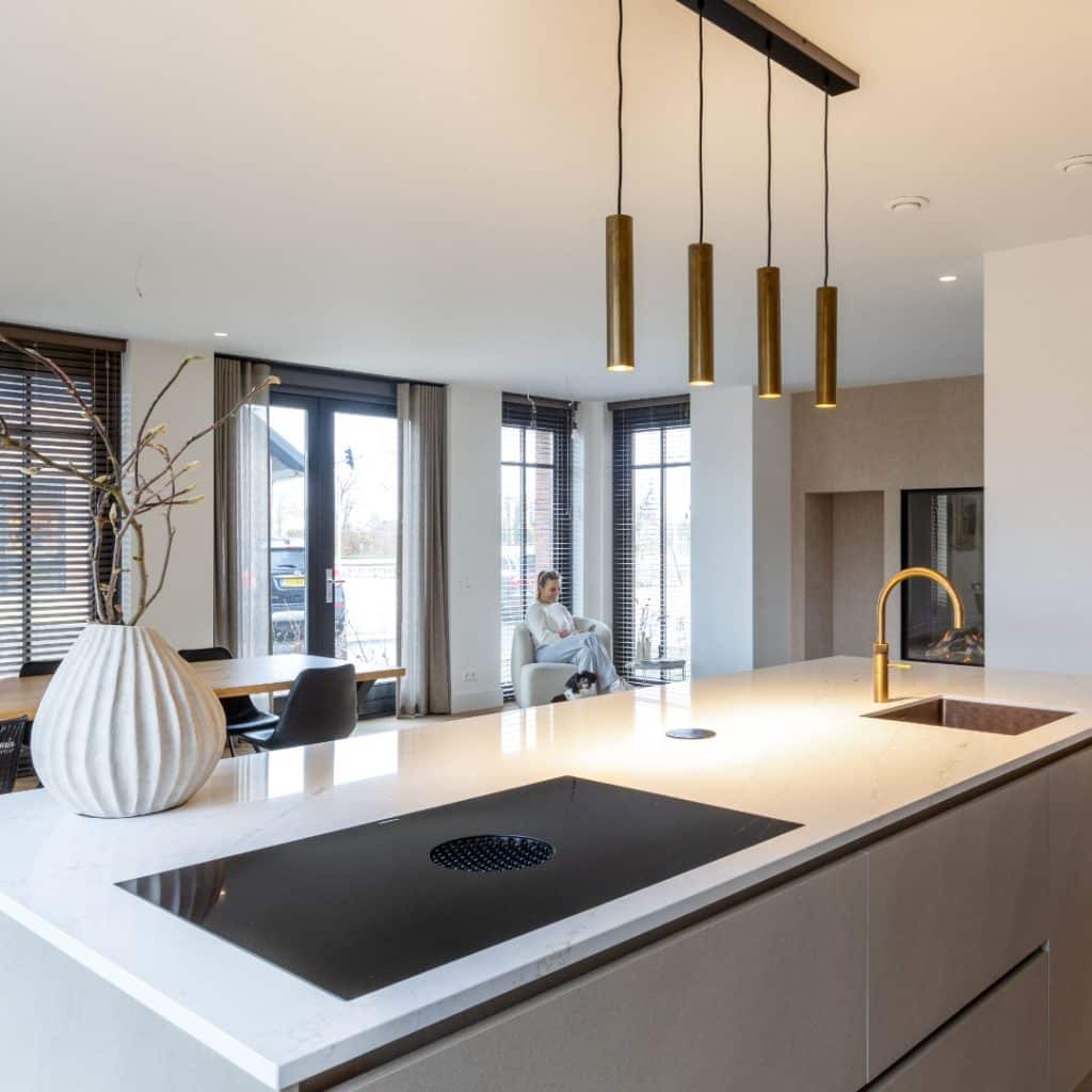 Sfeerbeeld van een luxe open keuken en woonkamer, beiden voorzien van beige Decolegno wanden